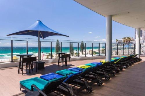 ゴールドコーストにあるSoul Luxury Apartment’sの長椅子とビーチパラソル