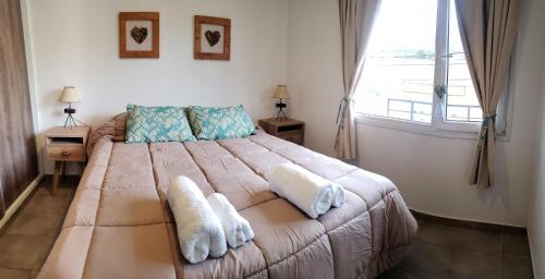 een slaapkamer met een groot bed en handdoeken bij Departamento Kuanip in Ushuaia