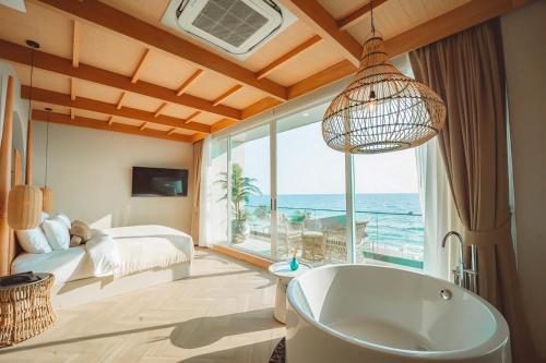 1 dormitorio con bañera, cama y ventana en Maldives Beach Resort, en Chao Lao Beach