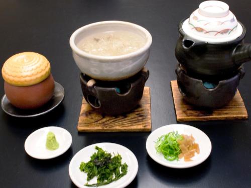 a table with bowls of soup and plates of food at Ryotei Yamanoi in Matsue