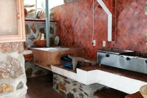 eine Küche mit einem Herd und einem Waschbecken in einem Zimmer in der Unterkunft Casa de Mamá Nico in Barrio Nuevo