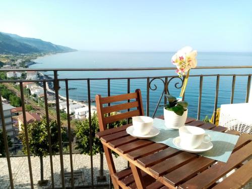 einen Holztisch mit einer Blume auf dem Balkon in der Unterkunft Un Oblò sul Mare in San Lucido