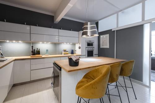 a kitchen with a counter and two stools at Elegant city home two blocks from Senate Square. in Helsinki