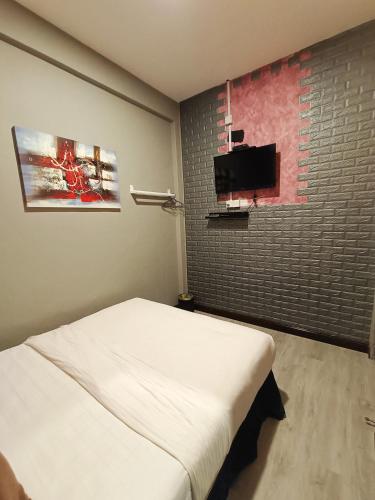 a bedroom with a bed and a flat screen tv at Tc theme park Guest house in Kuantan