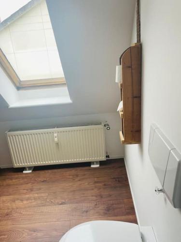 a bathroom with a toilet and a skylight at Gemütliche Stadtwohnung “Elmrand“ mit Stadtblick in Schöppenstedt