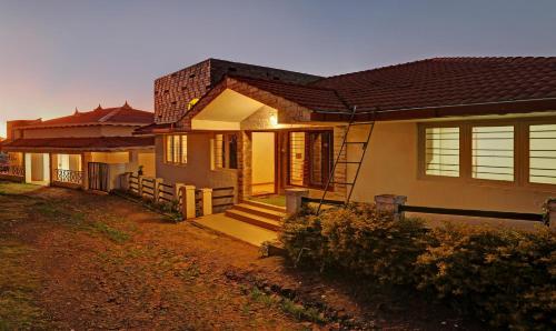 a house with a porch and stairs in front of it at Itsy Hotels Twin Falls in Ooty