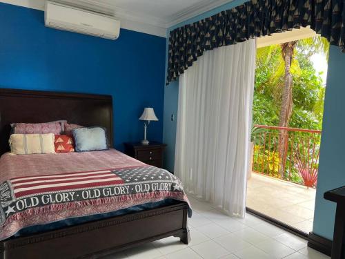 1 dormitorio con 1 cama y puerta corredera de cristal en Room in Apartment - Agradable Habitacion En Playa Flamingo, en Playa Flamingo