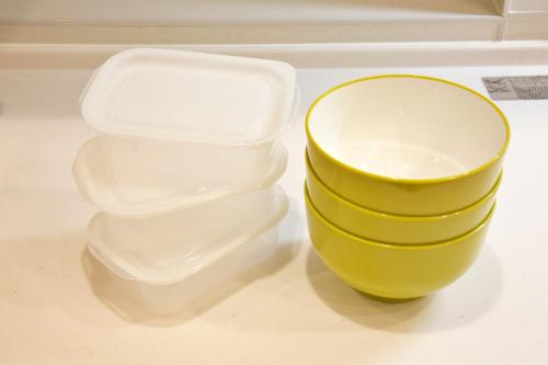a plastic container and a yellow bowl on a counter at 癒しの空間 One Earth in Akamine