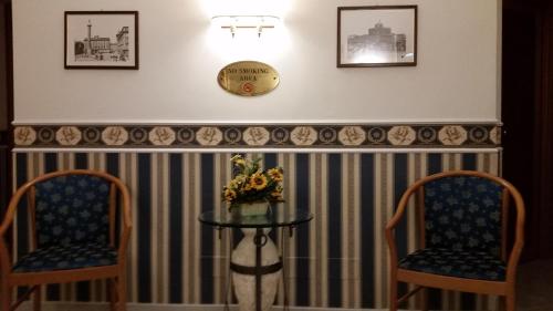 two chairs and a table with a vase of flowers at Hotel Teti in Rome