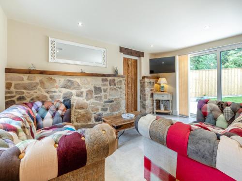 a living room with two couches and a stone wall at The New Stables in Melbourne