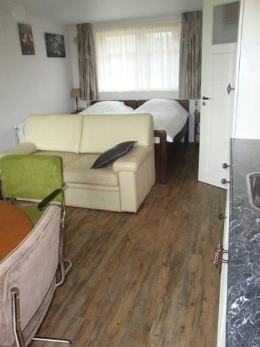 a living room with a couch and a bed at Bed and breakfast De Zwanebloem in Elburg