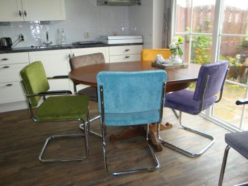 a kitchen with a table and four chairs at Bed and breakfast De Zwanebloem in Elburg
