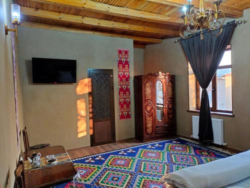 - une chambre avec un lit et un tapis au sol dans l'établissement Darvozai Samarkand guest house, à Samarcande