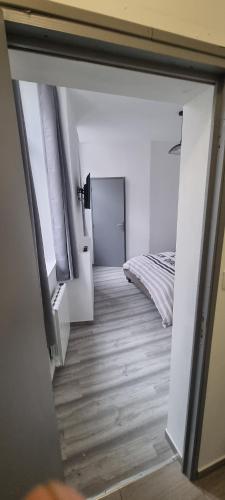 - une vue sur une chambre avec un lit et un couloir dans l'établissement air cosy valenciennes gare activité illégales interdit, à Valenciennes