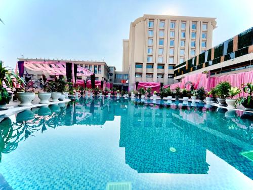uma grande piscina de água com plantas e edifícios em The Mars Resorts em Meerut