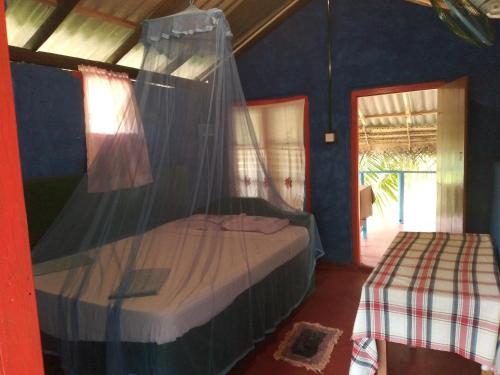 a bedroom with a bed with a mosquito net at Star Sun Homestay in Tangalle