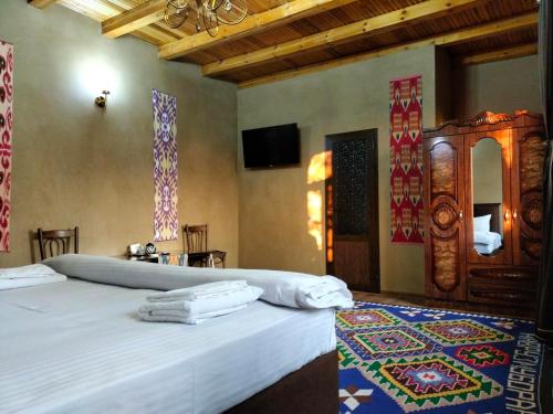 a bedroom with a bed and a tv on the wall at Darvozai Samarkand guest house in Samarkand