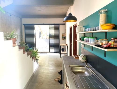uma cozinha com um lavatório e uma parede azul em The Traveller Kandy em Kandy