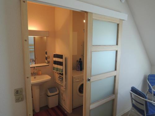 een badkamer met een wastafel en een wasmachine bij Joli appartement avec wifi sur le port de Dahouet in Pléneuf-Val-André