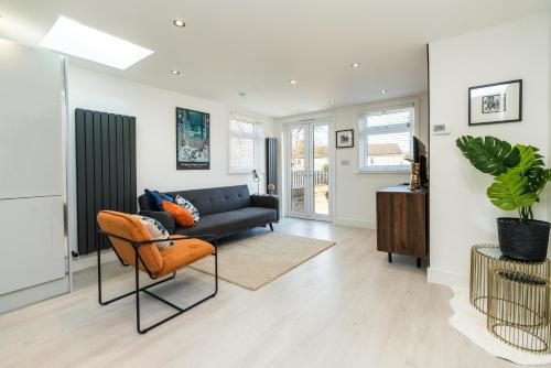 a living room with a couch and a chair at Spacious Modern 2 Bedroom London Flat in Sydenham