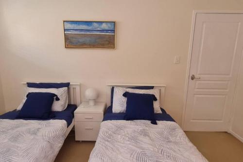 een slaapkamer met 2 bedden en een foto aan de muur bij Happy Haven at Eight Mile in Brisbane