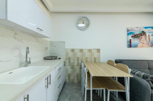a kitchen with a sink and a table and a couch at Kings suite at Royal Park Eilat in Eilat