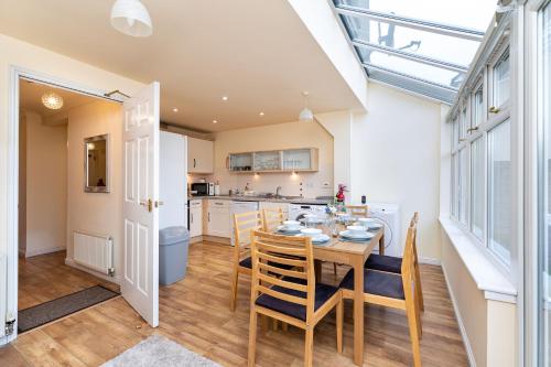 a kitchen and dining room with a table and chairs at 4 Bedroom Townhouse in Stirling in Stirling