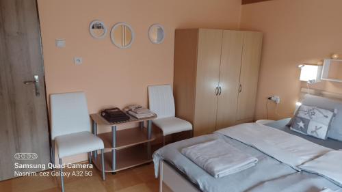 a bedroom with a bed and a table and chairs at Apartmán 81 in Nová Lesná
