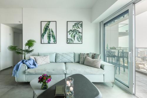 sala de estar con sofá y mesa en Beautiful 2br in midtown w sea view, pool and parking by Sea N' Rent, en Tel Aviv