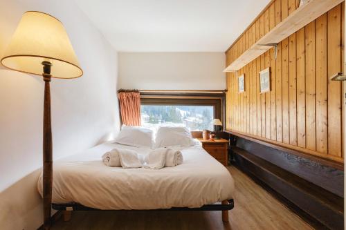 1 dormitorio con 1 cama con lámpara y ventana en Résidence Grand Roc - Campanules 415 - Happy Rentals en Chamonix-Mont-Blanc