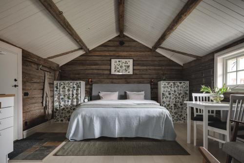 1 dormitorio con 1 cama en una habitación con paredes de madera en Smålandstorpet, en Hok