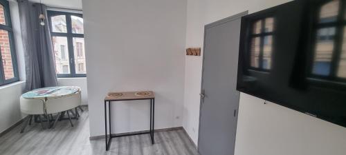 Cette chambre comprend une table et un tabouret. dans l'établissement Air Cosy 2 Valenciennes gare prostitution refusée, à Valenciennes