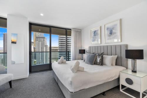 a bedroom with a large bed and a large window at Oracle Resort Broadbeach - gclr in Gold Coast