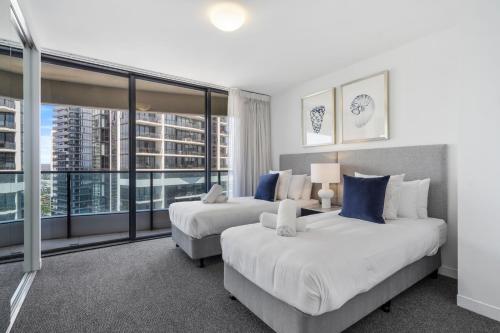 a hotel room with two beds and a large window at Oracle Resort Broadbeach - gclr in Gold Coast
