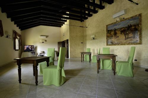 una habitación con mesas y sillas y un cuadro en la pared en Hotel Tenuta San Francesco, en Barletta