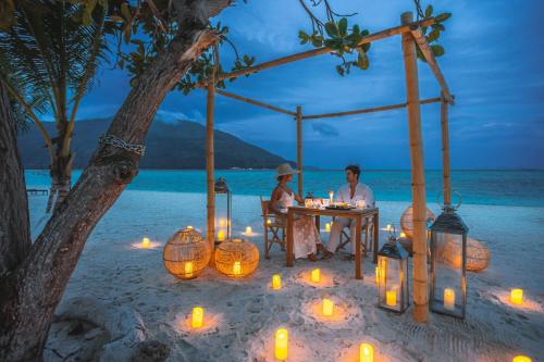 a couple sitting at a table on a beach with candles at Irene Pool Villa Resort, Koh Lipe in Ko Lipe