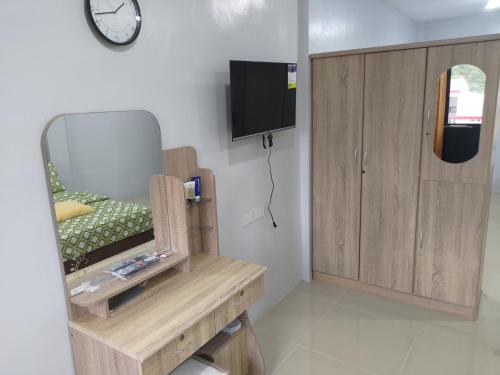 Zimmer mit einem Stuhl und einem TV an der Wand in der Unterkunft JLF Inn in Locsin