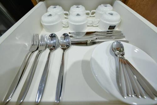 a white table with silver utensils on a white plate at The Apartments at El Nido in El Nido