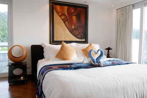 Schlafzimmer mit einem Bett mit Herzdekoration in der Unterkunft Kata Ocean View Condominium, Seaview & Luxury K12 in Ban Kata