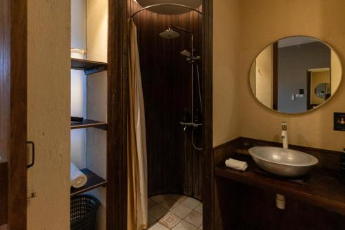 a bathroom with a shower and a sink and a mirror at Tanaga CoLiving in Seminyak