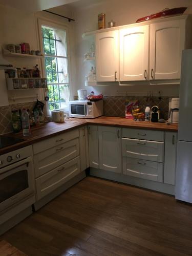 a kitchen with white cabinets and a white refrigerator at Villa Gif Sur Yvette centre - Paris Olympic game 2024 visitors in Gif-sur-Yvette