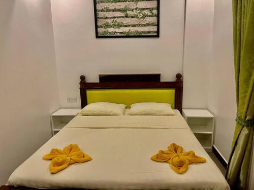 a bedroom with a bed with two yellow flowers on it at Private and Unique Stay At Angkor Siem Reap in Phumĭ Réach Born (2)