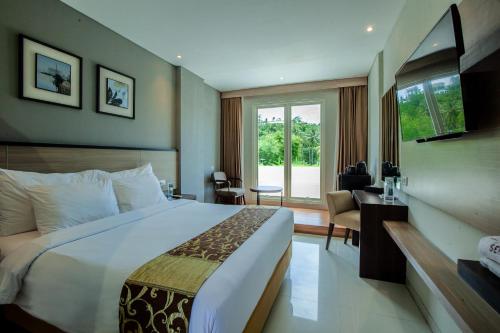 Habitación de hotel con cama grande y ventana en Montana Premier Senggigi en Senggigi 