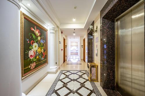 um corredor com uma pintura de flores na parede em Acnos Grand Hotel em Ho Chi Minh