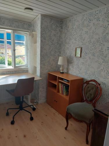 een kamer met een bureau, een stoel en een tafel bij Guest room in Uppsala