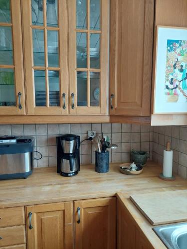 a kitchen with wooden cabinets and a coffee maker on a counter at Guest room in Uppsala