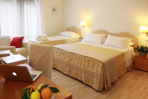 a hotel room with two beds and a laptop on a table at Residenza Giacomuzzi in Mestre