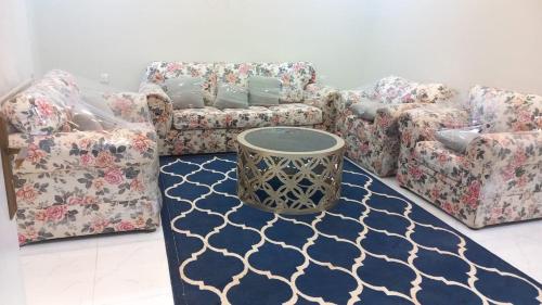 a living room with couches and a table on a rug at فيلا الكادي in Al Hada