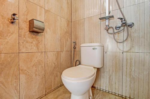 a bathroom with a toilet and a shower at OYO 92294 Amole Homestay Syariah in Cilacap