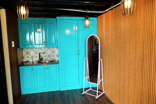 a kitchen with blue cabinets and a pink ladder at Roses Villa Tam Dao - Venuestay in Tam Ðảo